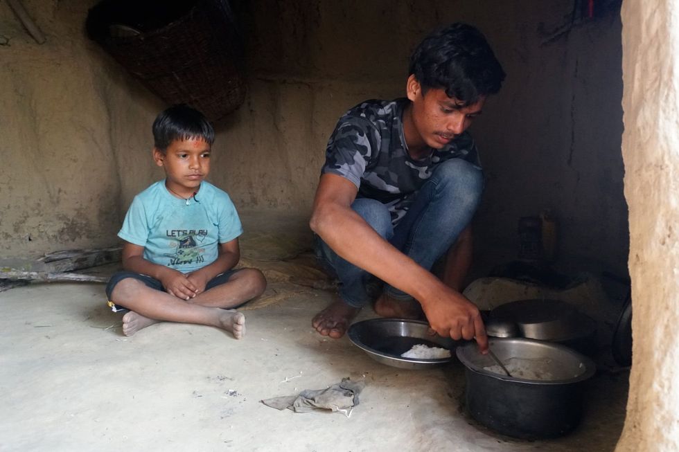 Prakash Jaisi, 18, prepares meals for his brother, Rajendra Ghodasaini, 6, at their family home.