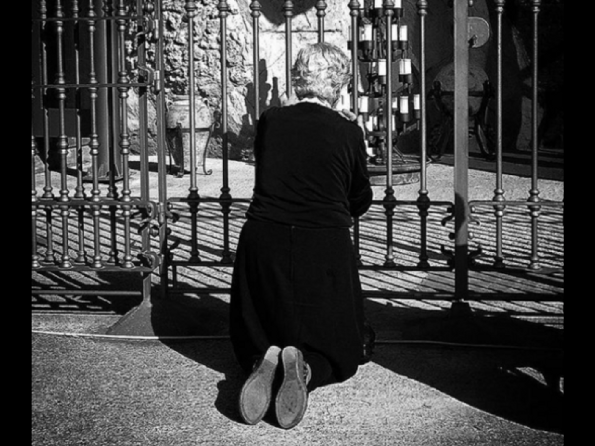 Praying in front of the Madonna dello Scoglio in Calabira