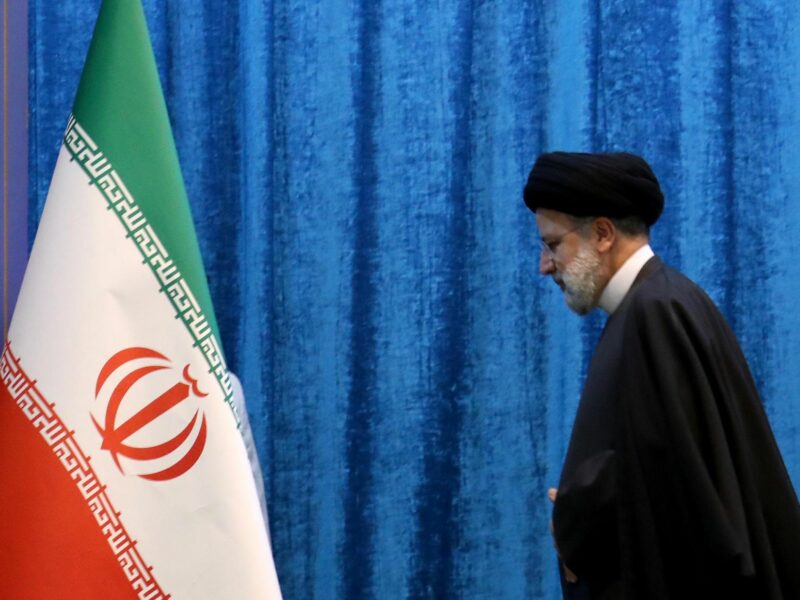 President Ebrahim Raisi looks at the Iranian flag.
