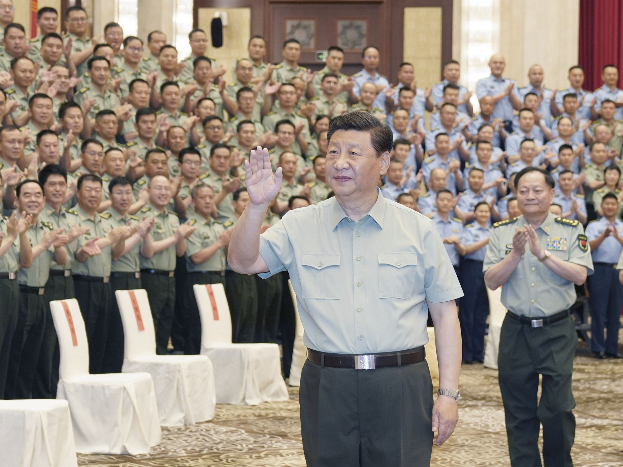 President Xi Jinping waves at lined up military officers and troops