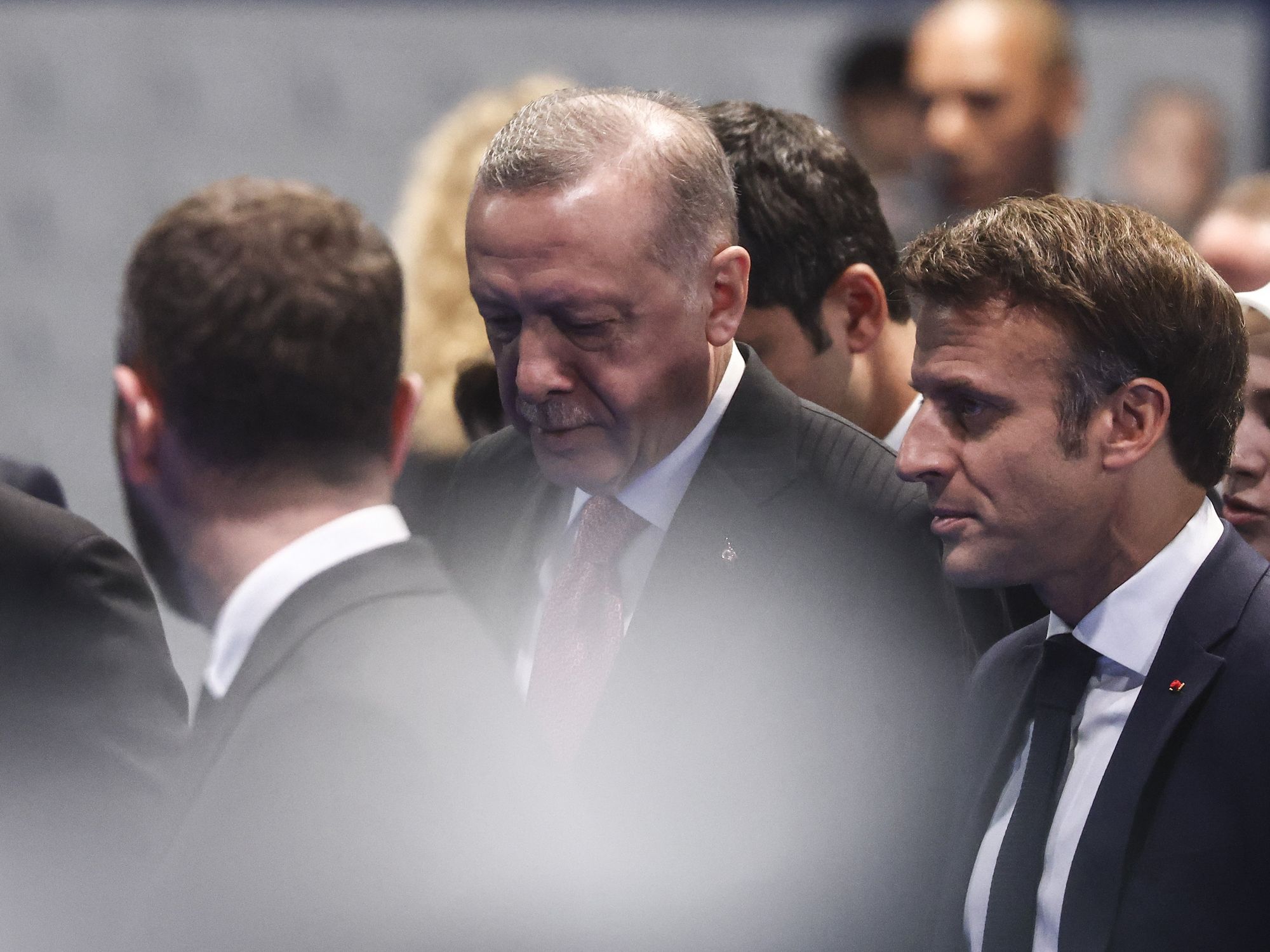 Presidents Erdogan and Macron in a crowd, slightly obscured by a lense flare