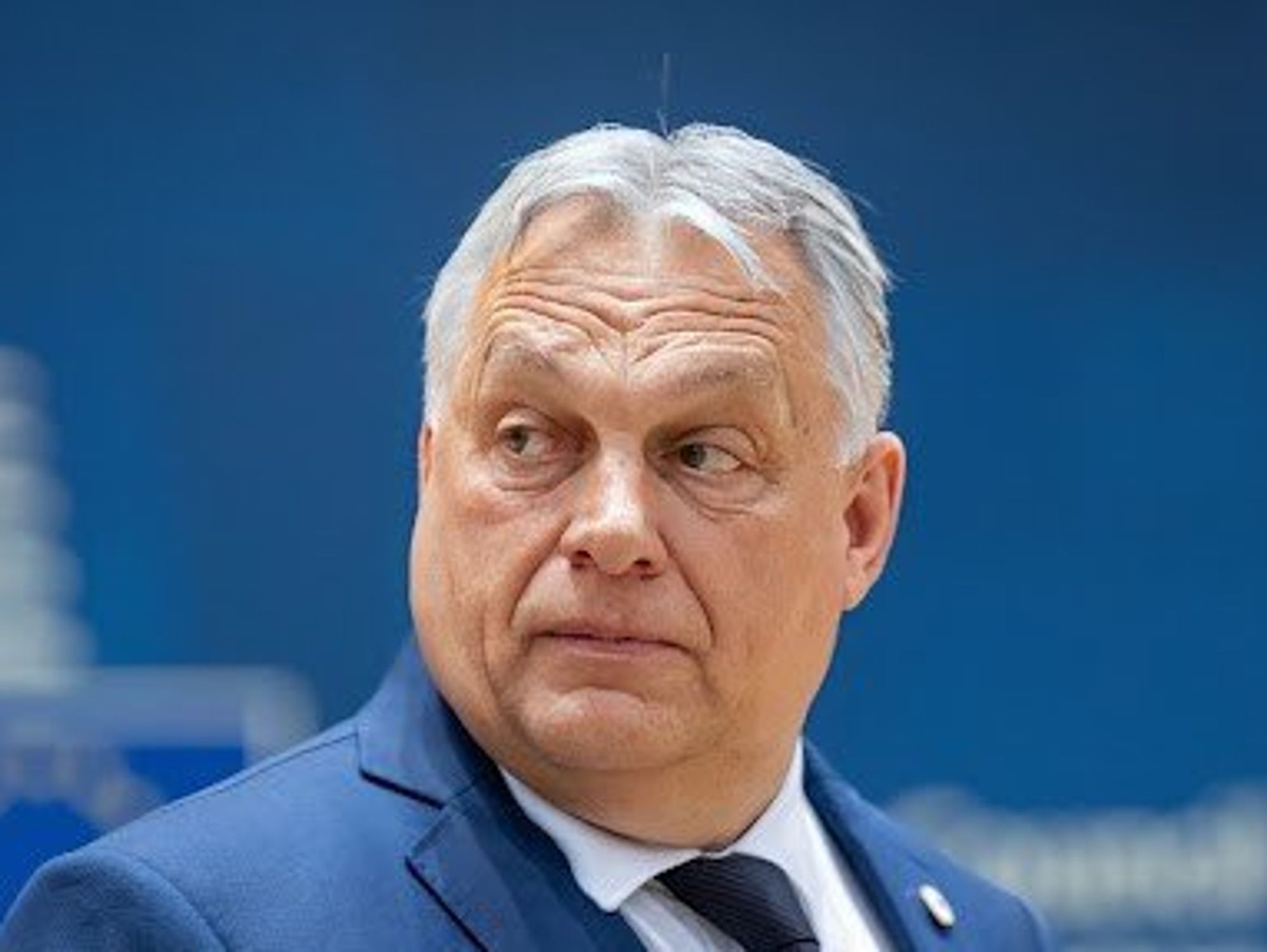 Prime minister Viktor Orban looking over his shoulder with a perplexed look on his face