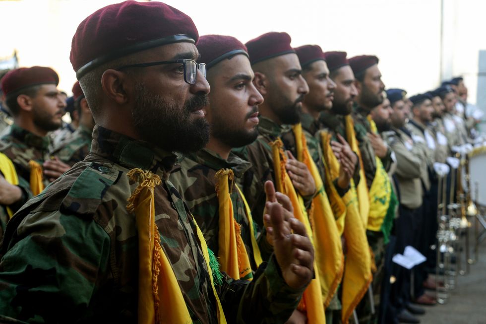 Pro-Iranian Hezbollah fighters beat on their chests as a sign or mourning during a ceremony to mark the 40th day of the assassination of the party top commander Fouad Shukur at a grave yard dedicated for Hezbollah militants.