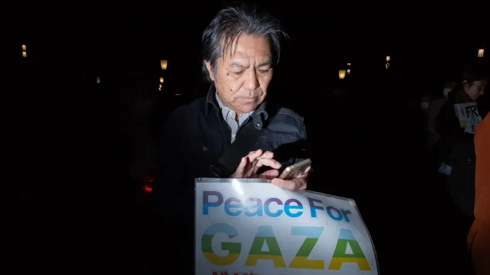 Pro-Palestine demonstrators hold a candlelight vigil outside Tokyo Station to pay tribute to the civilian victims of Israeli airstrikes in Gaza.