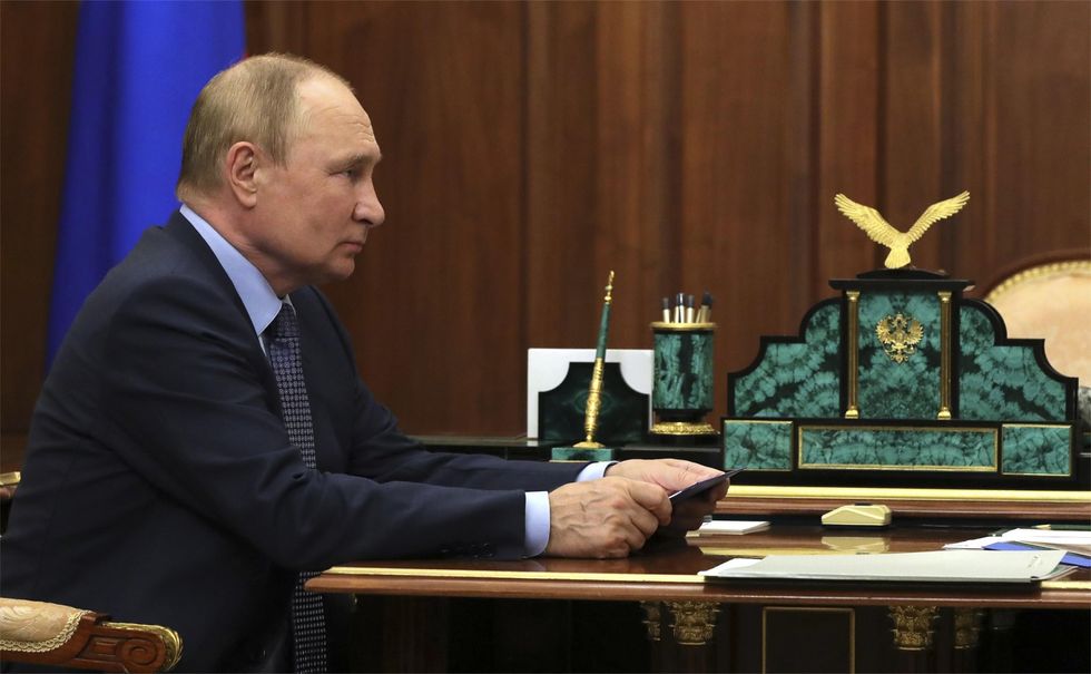 Profile view of Russian President Vladimir Putin at a desk during a face-to-face meeting with the newly appointed chairman and CEO of Aeroflot, Sergei Alexandrovsky, at the Kremlin