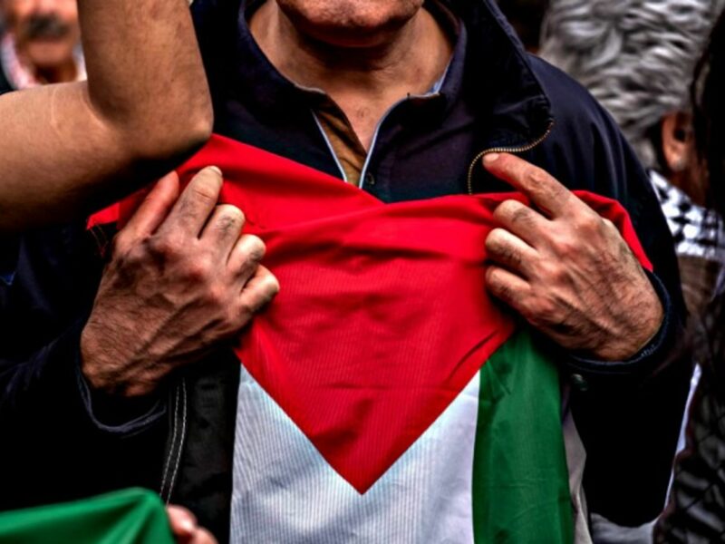 Protester holding a Palestinian flag to his chest