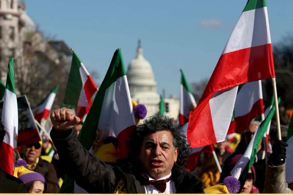 Protesters carrying Iranian flags march in the streets of Washington with the U.S. Capitol Building behind them