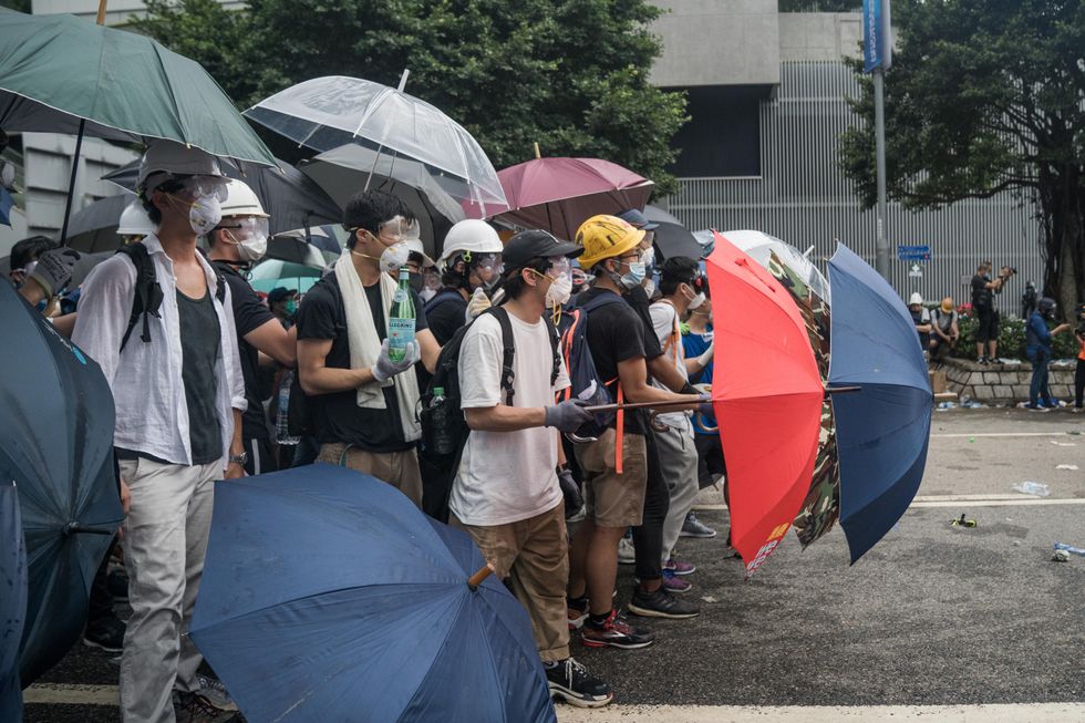 Protesters defending themselves from pepper spray and tear gas during the 2019 protests in Hong Kong over an extradition bill.