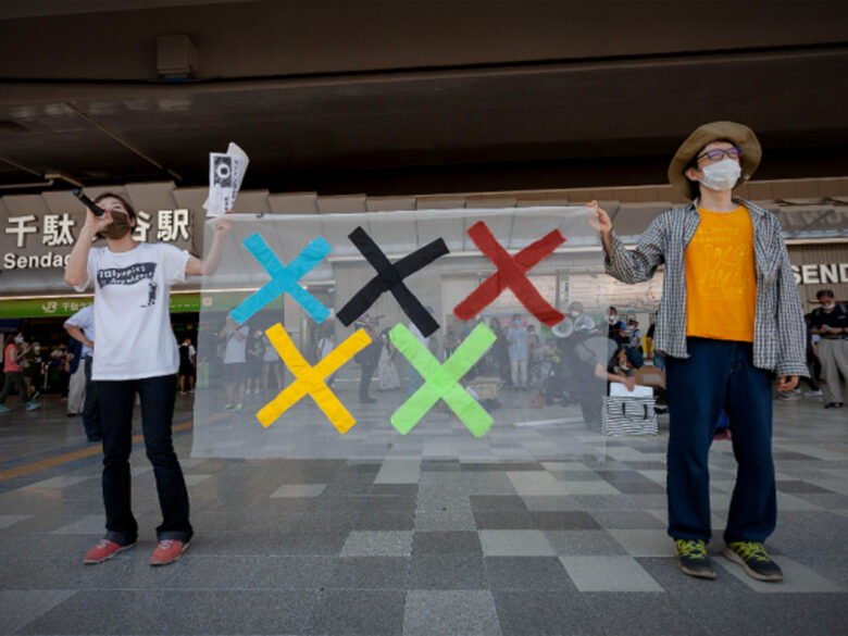 Protesters hold a banner during a protest against the 2020 Tokyo Olympics in front of Sendagaya Station on July 23