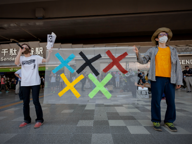 Protesters hold a banner during a protest against the 2020 Tokyo Olympics in front of Sendagaya Station on July 23