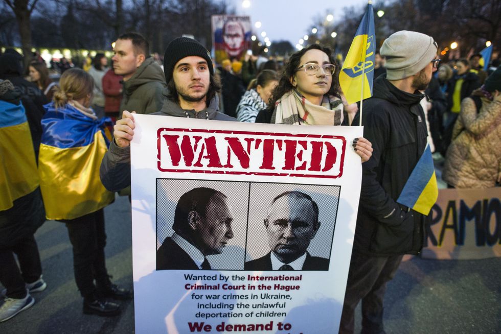 Protesters hold a placard expressing their opinion during the anti-war protest. Several thousands of Ukrainian refugees living in Warsaw and Polish citizens gathered outside Russia's Embassy in Warsaw marched to the parliament to show support for Ukraine and condemn the war.