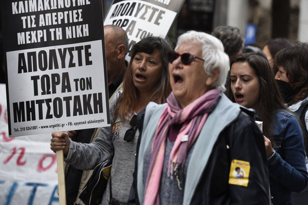 Protesters hold banners and placards in Greek