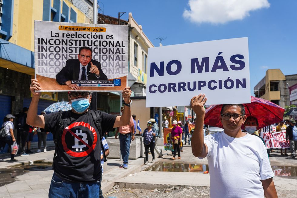 Protesters hold placards during a demonstration against the Bukele administration on El Salvador's independence day