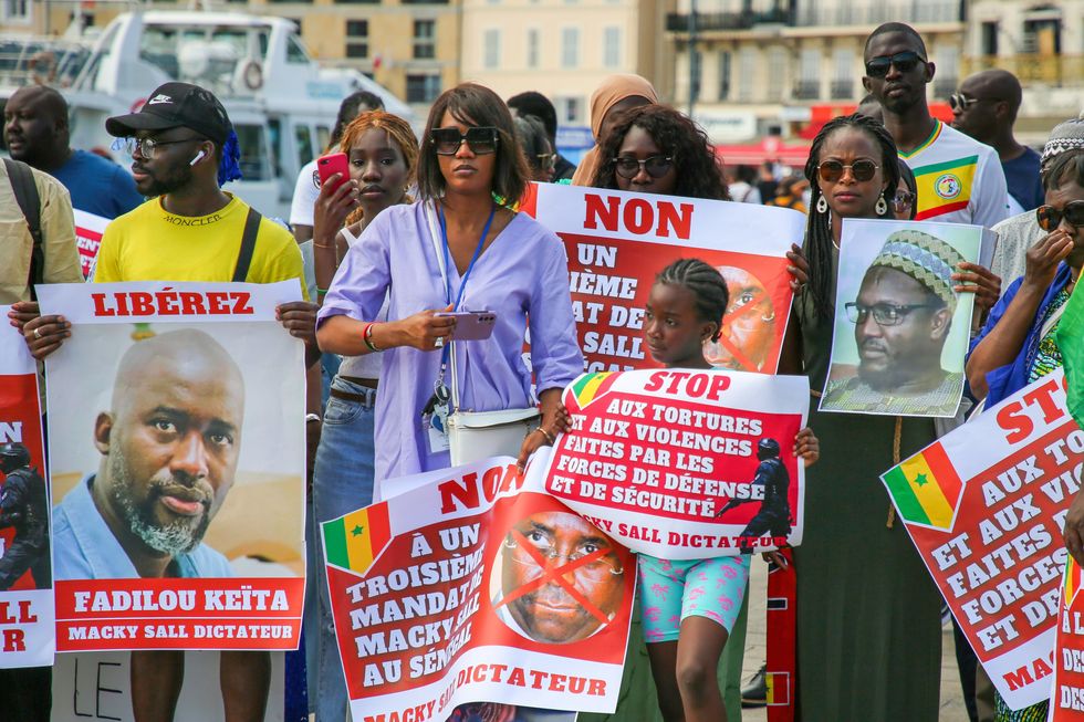 Protesters hold placards expressing their opinions during the demonstration against the dictatorship of Senegalese President Macky Sall The Party of African Patriots of Senegal for work.