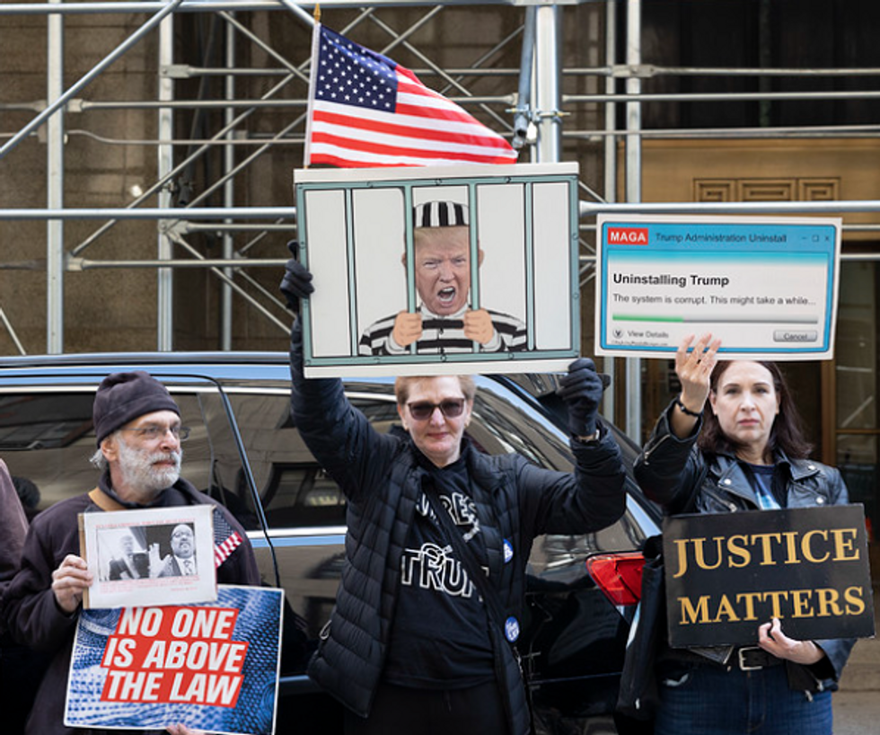 Protesters holding anti-Trump signs outside of the New York City Criminal Court on March 29.