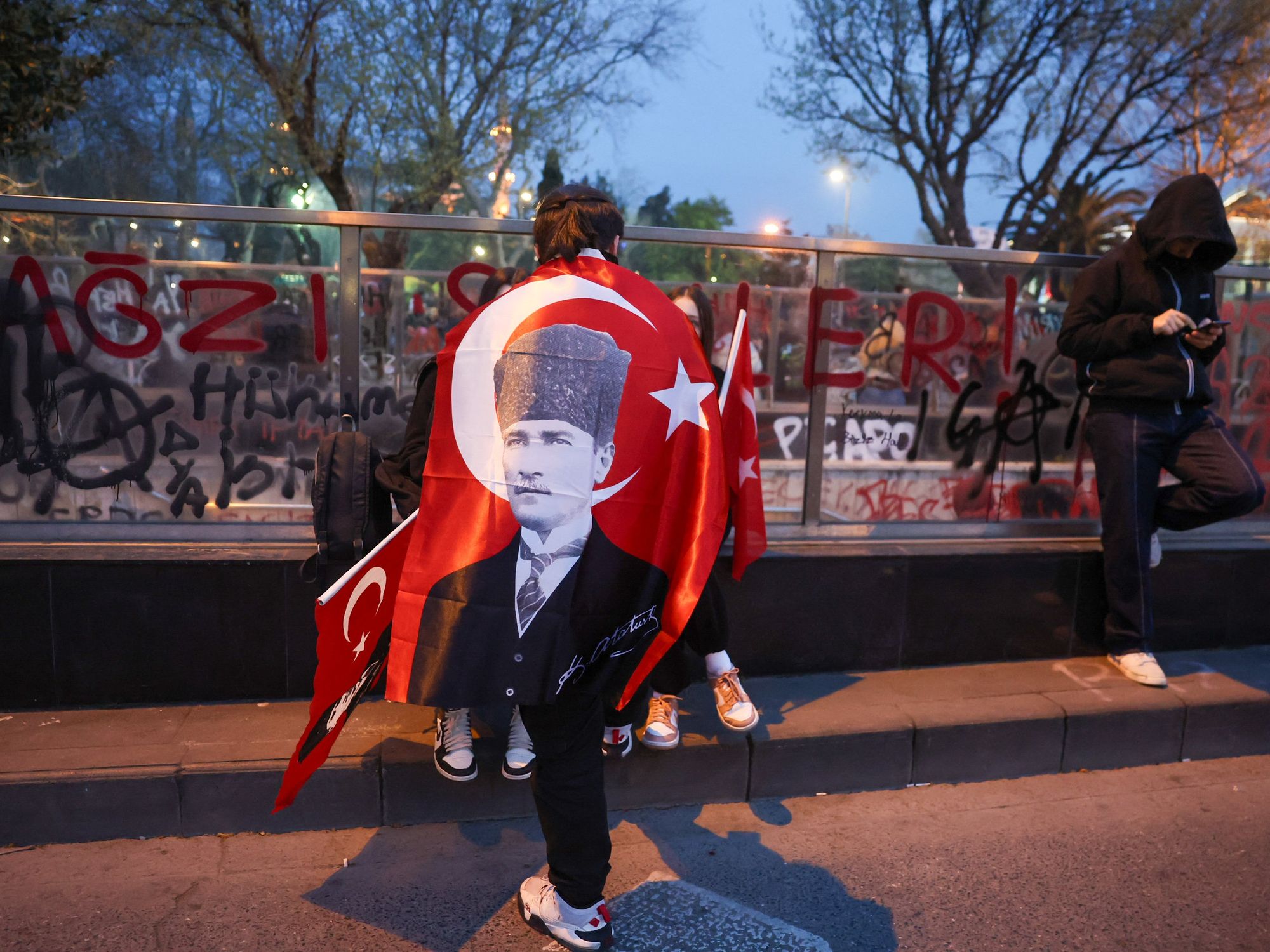 Protesters wave Turkish flags during a 7th nighttime rally in Istanbul, Turkey, on March 25, 2025.