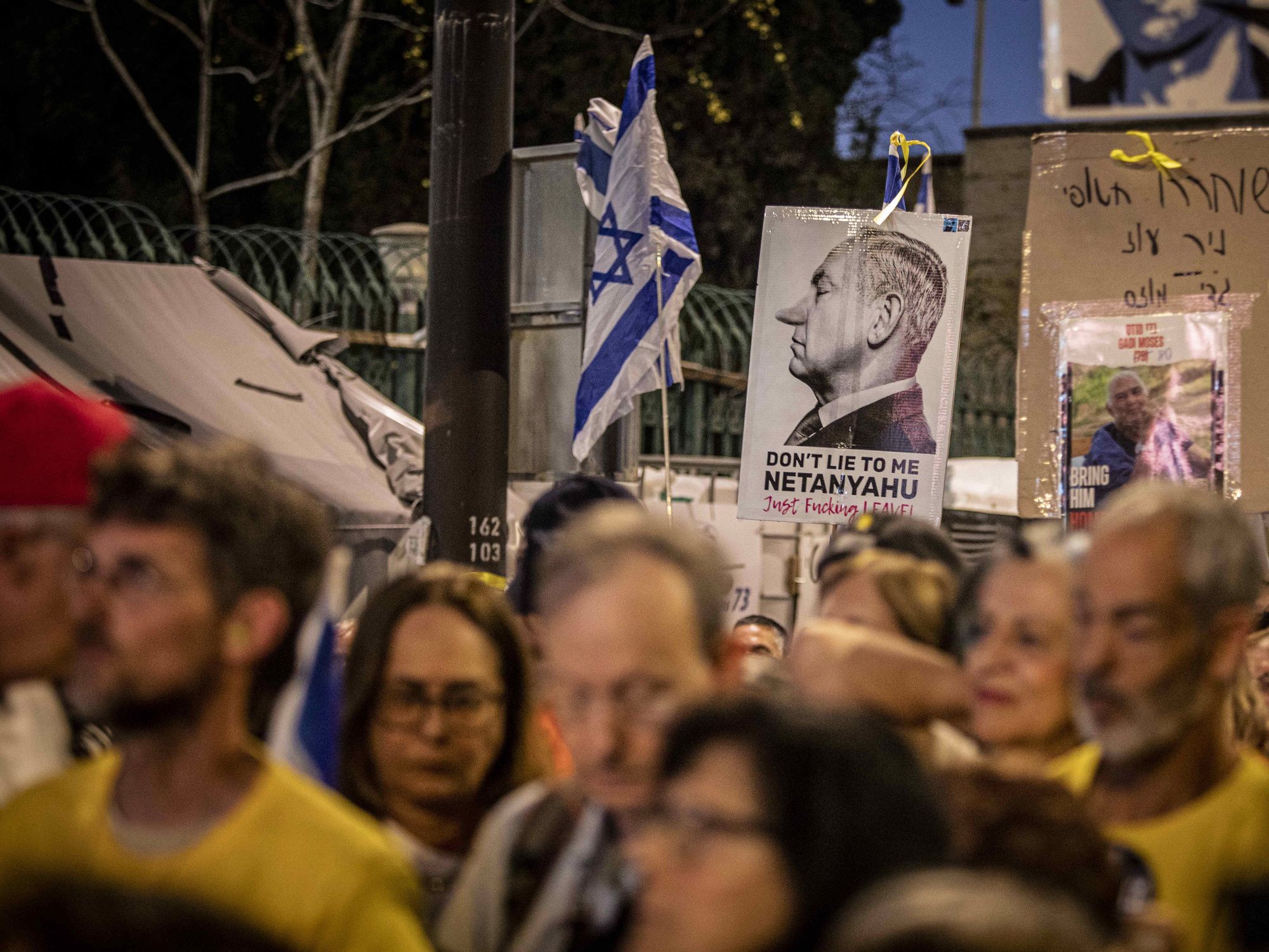 Protestors hold up a placard showing Israeli Prime Minister Benjamin Netanyahu.