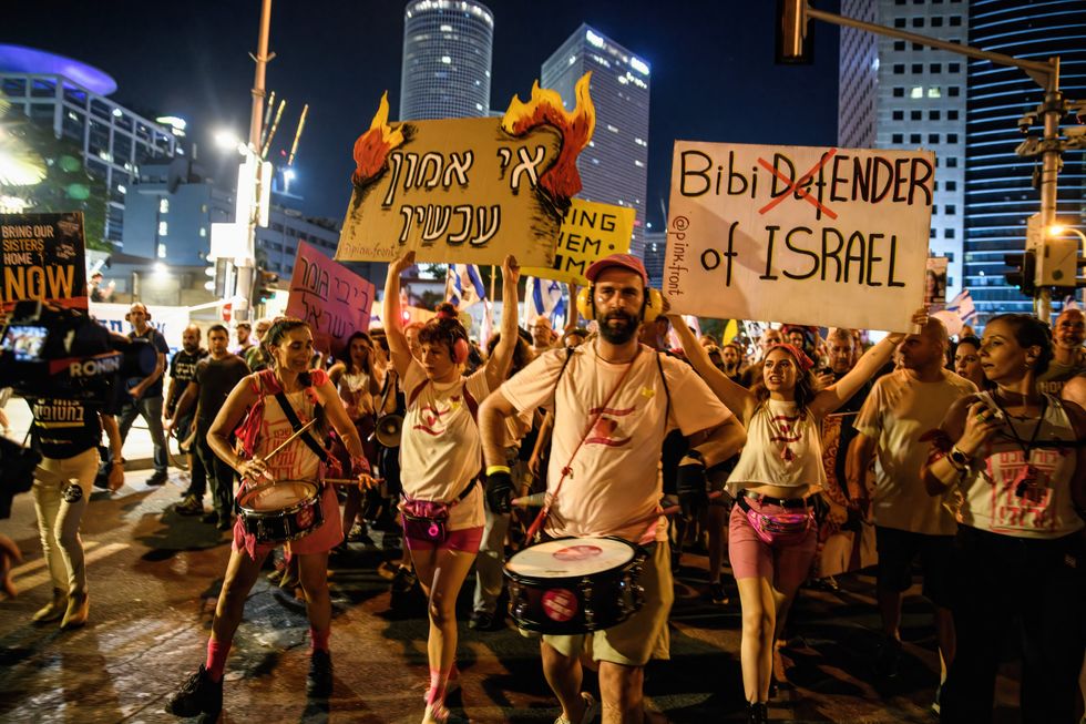 Protestors march with signs that read ''Bibi DefENDER of Israel'' and ''Vote of no confidence Now'' during the demonstration.