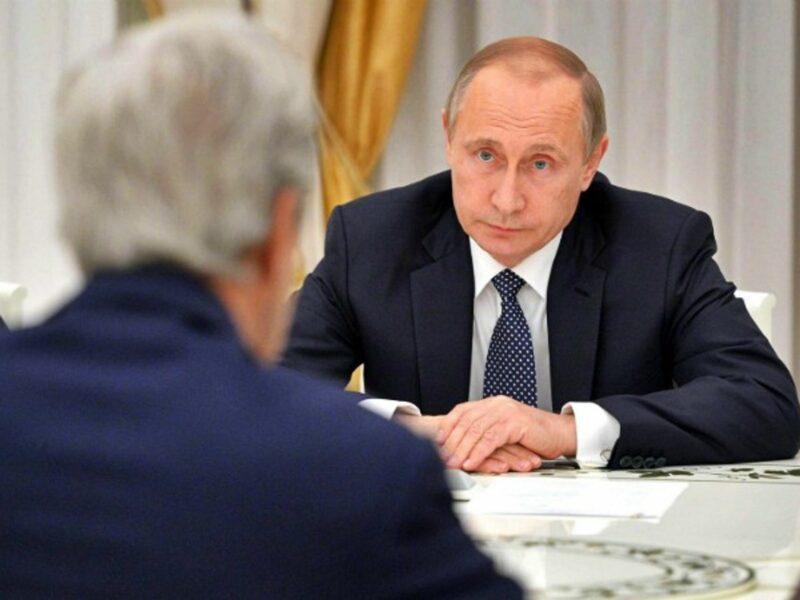 Putin facing U.S. Secretary of State John Kerry.
