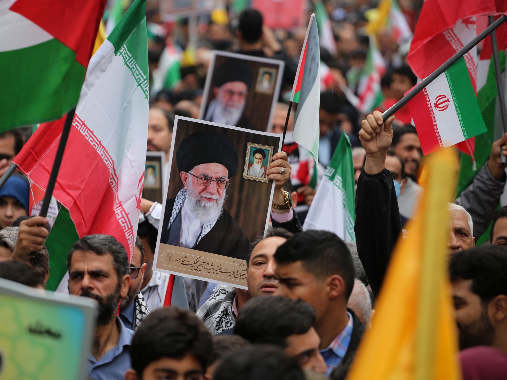 ranian demonstrators hold a portrait of Iranian Supreme Leader Ayatollah Ali Khamenei.