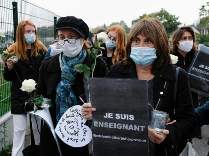 Recalling the 'Je suis Charlie' slogan, an 'I am (a) teacher' sign in solidarity with the victim.