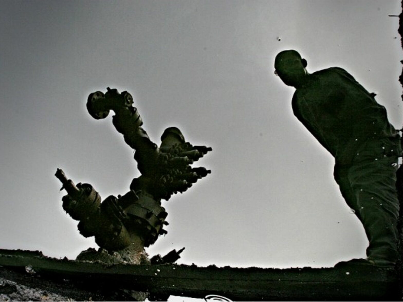 Reflection of a man in a crude oil spill in Ogoni, Nigeria