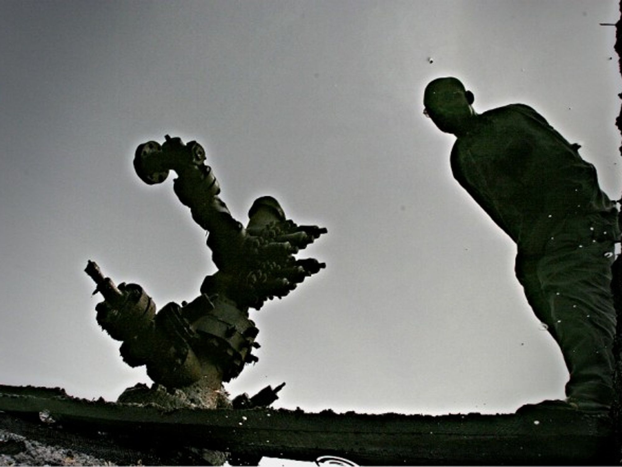 Reflection of a man in a crude oil spill in Ogoni, Nigeria