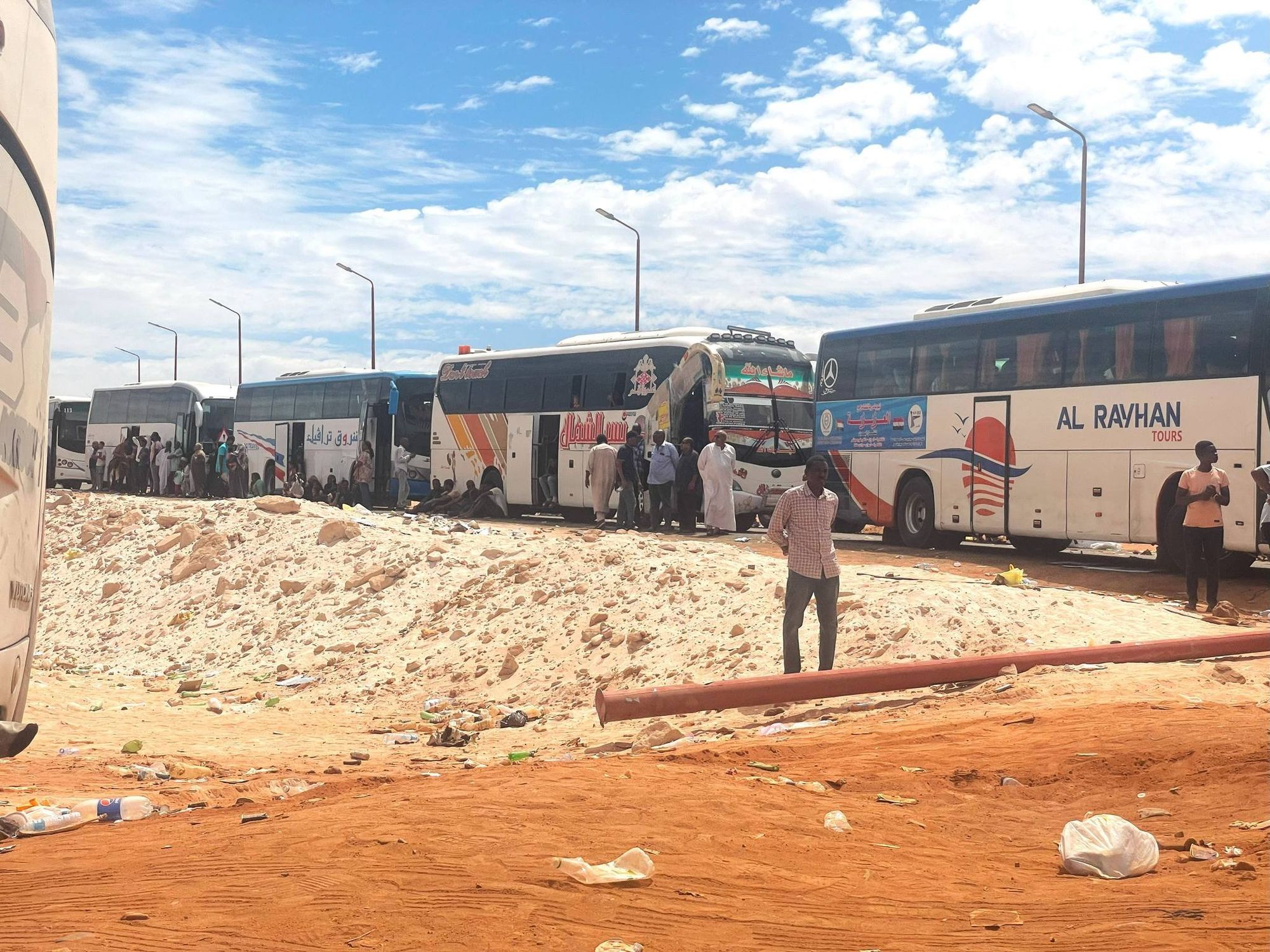 Refugees offloading from buses.