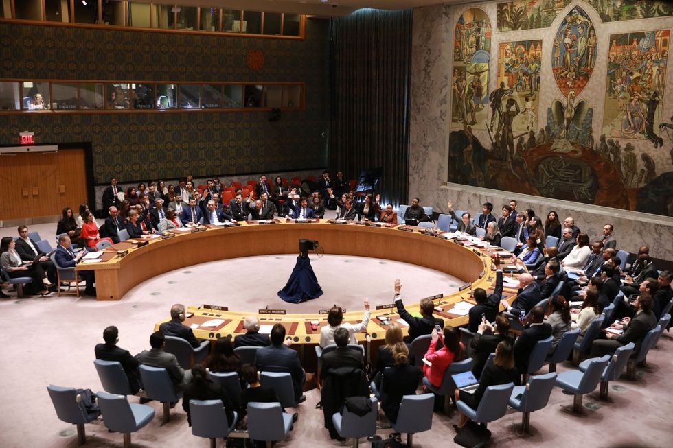 Representatives vote on a draft resolution during a Security Council meeting at the UN headquarters in New York.