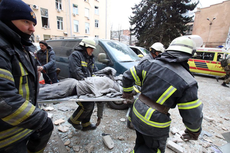 Rescuers carry a wounded person on the stretcher after a shelling by Russian troops of central Kharkiv