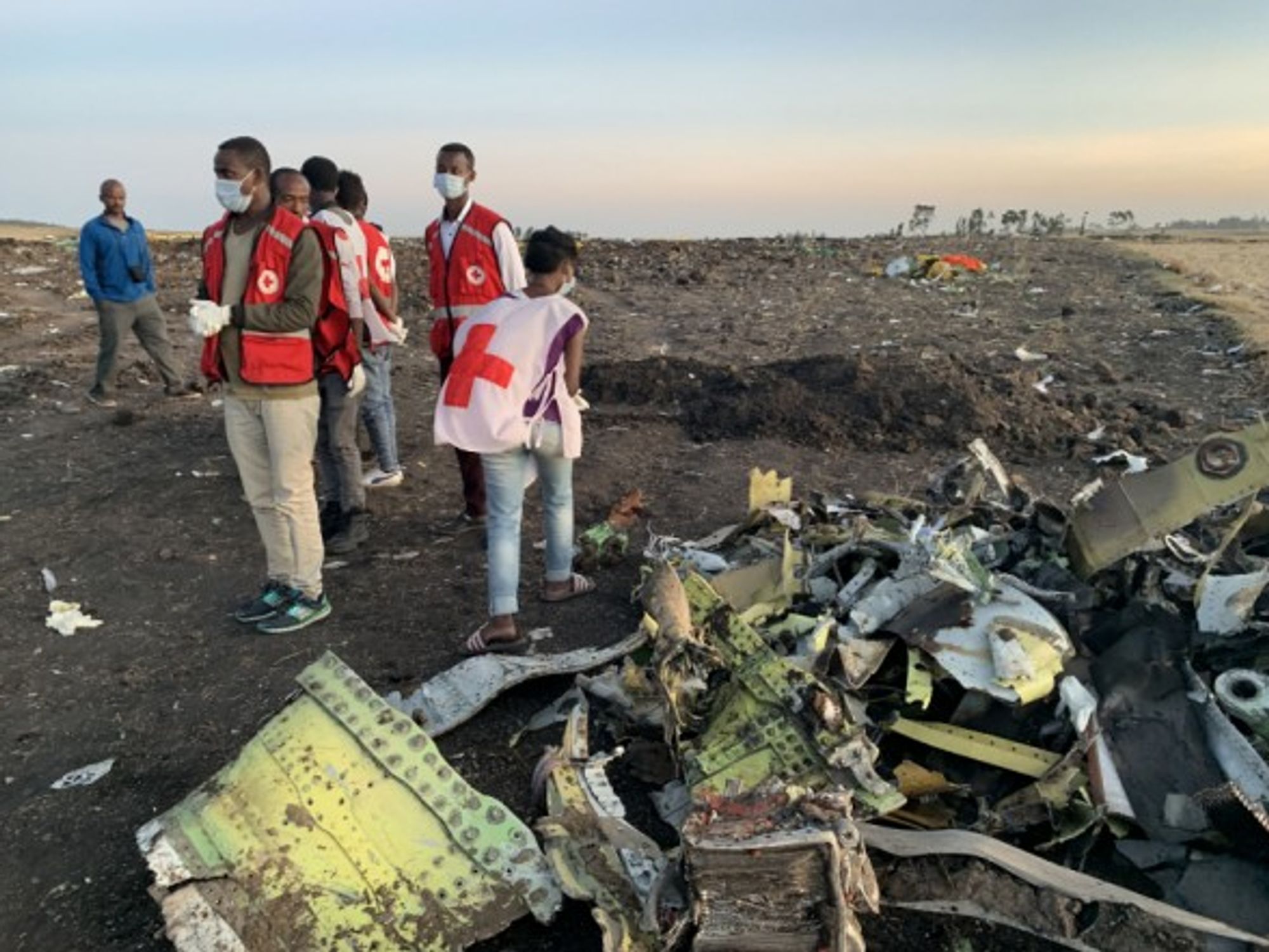 Rescuers work beside the wreckage of an Ethiopian Airlines' aircraft at the crash site