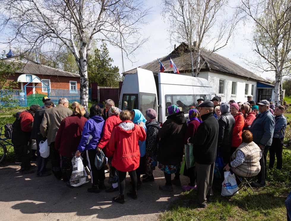 Residents queue to receive food aid in the village of Krymske, Ukraine
