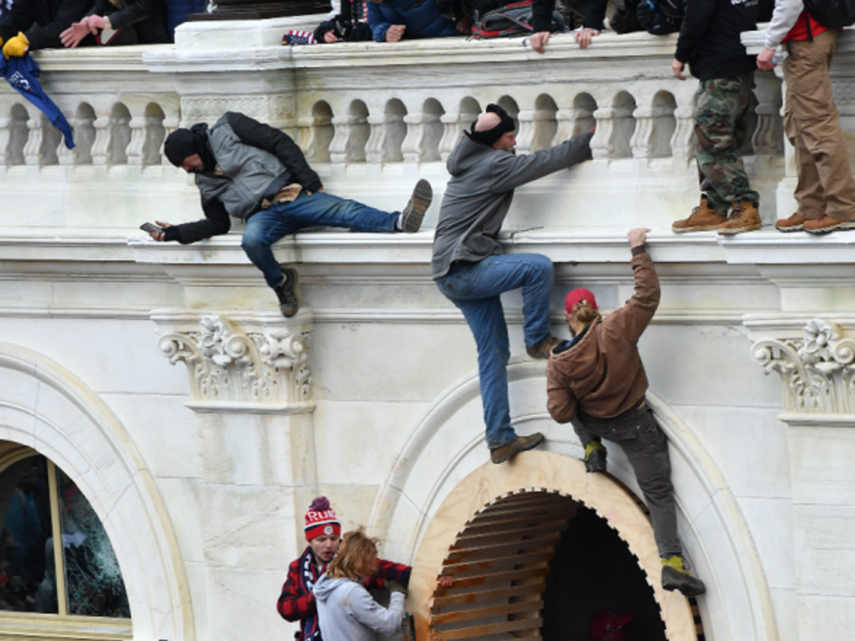 Rioters climb the wall of the U.S. Capitol in Washington, D.C. on Wednesday.