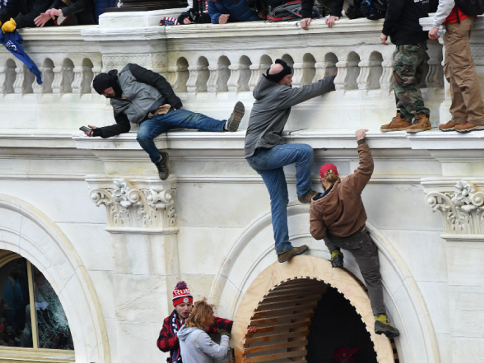 Rioters climb the wall of the U.S. Capitol in Washington, D.C. on Wednesday.
