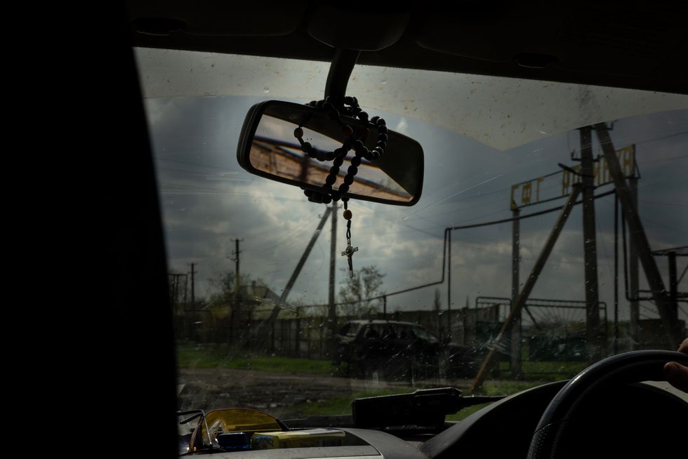 Rosary beads from the rearview mirror of a Ukrainian military vehicle outside of Bakhmut