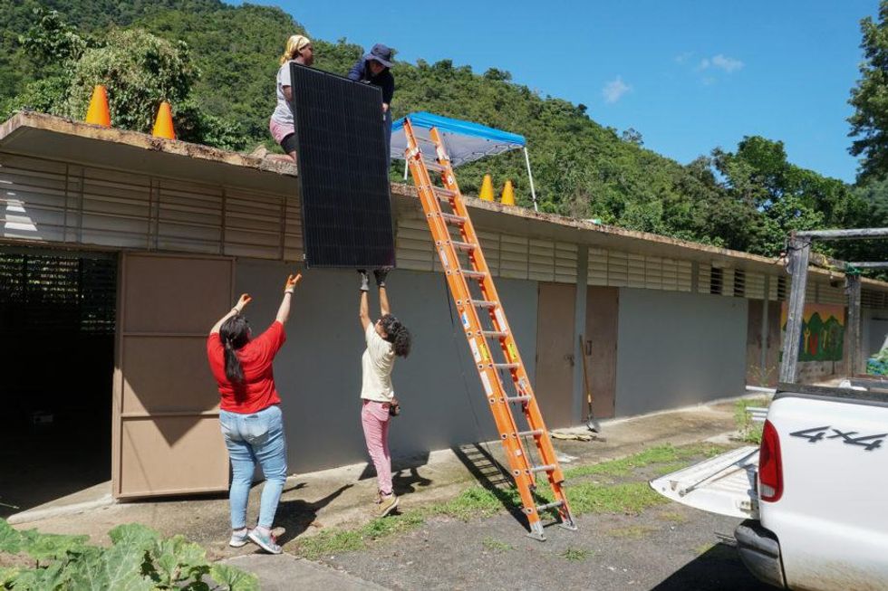 Roselyn M. Vélez Rodríguez, Hana Lynn, Yari Taína Rodríguez and Alanis Delgado work together to install 12 solar panels at Ángel G. Rivera Community School, which now serves as an agricultural school and emergency center.