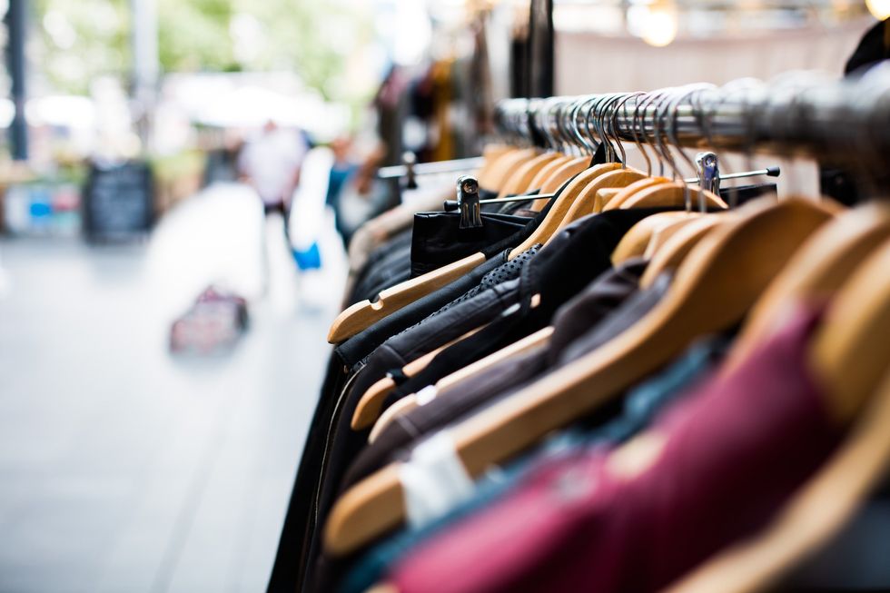 Row of clothes on hangers and hangers outside in front of a shop
