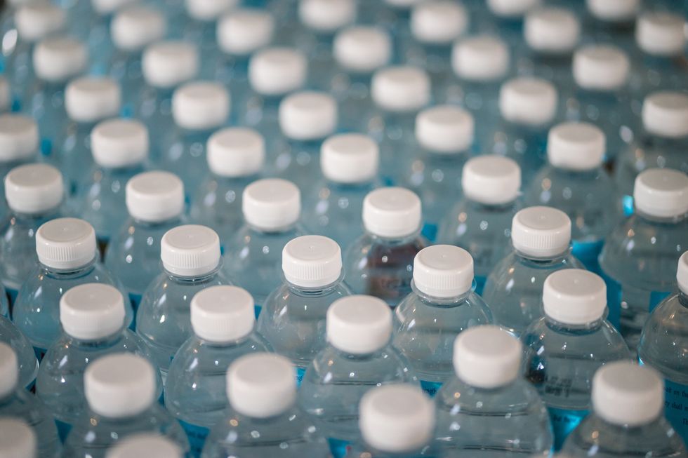 Rows of plastic waterbottles are stood upright in lines