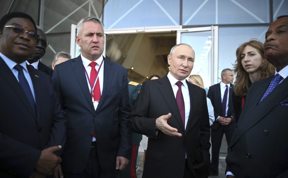 Russian President Vladimir Putin, center, speaks to Congo President Denis Sassou Nguesso, right, through the interrupter during Navy Day celebrations, July 30, 2023 in St. Petersburg, Russia.