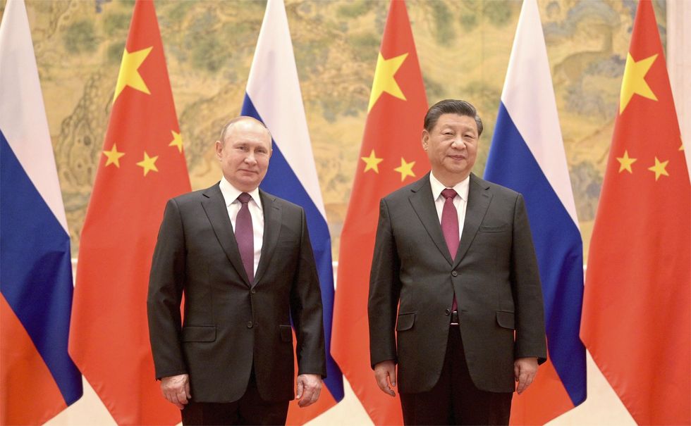 Russian President Vladimir Putin stands with Chinese President Xi Jinping