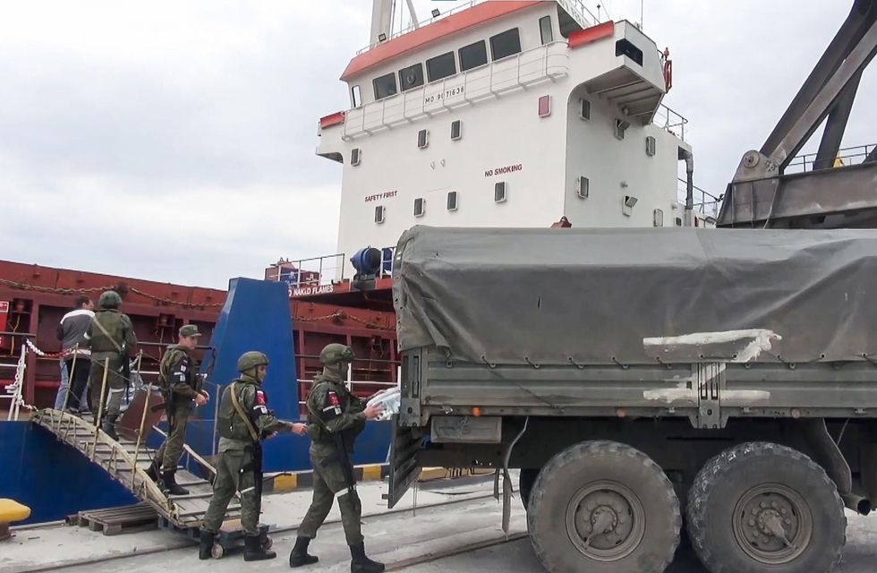 Russian servicemen distribute humanitarian aid to crew members in Kherson