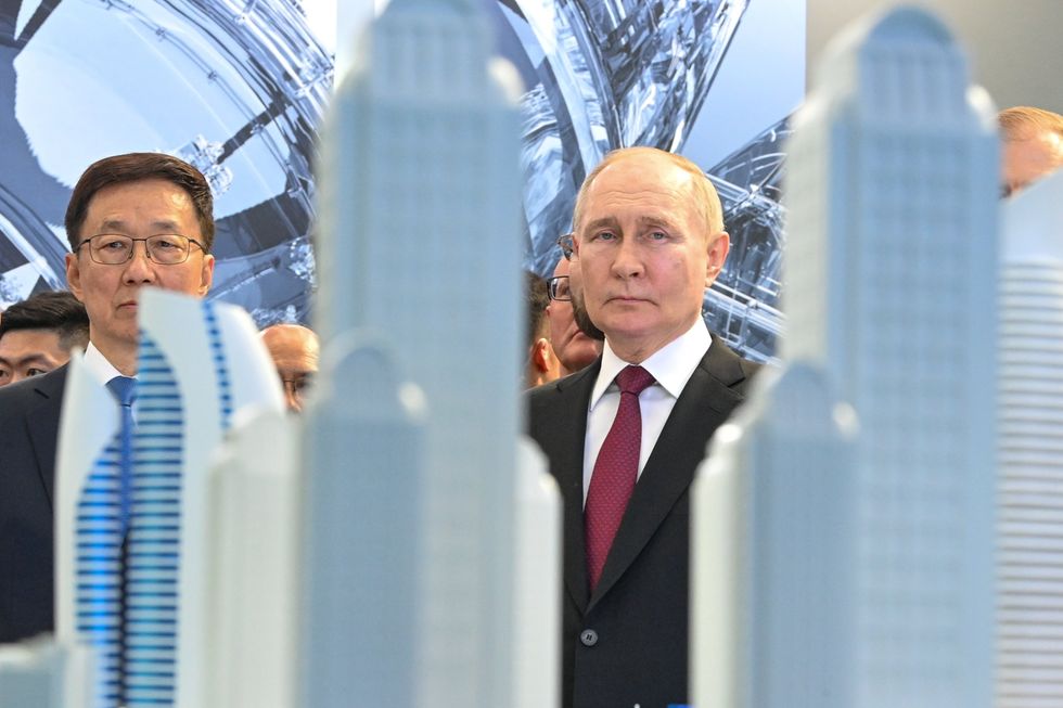 Russia's President Vladimir Putin and China's Vice President Han Zheng attend an exhibition as part of the 8th China-Russia Expo