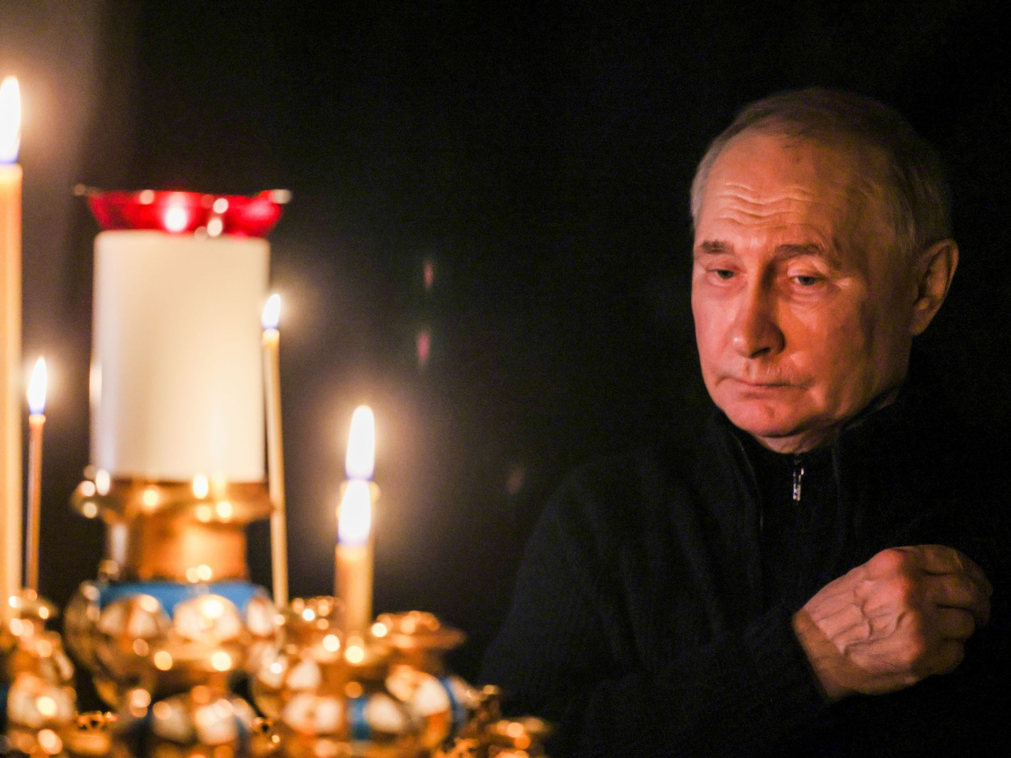 Russia's President Vladimir Putin lights a candle to commemorate victims of a terrorist attack on the Crocus City Hall.