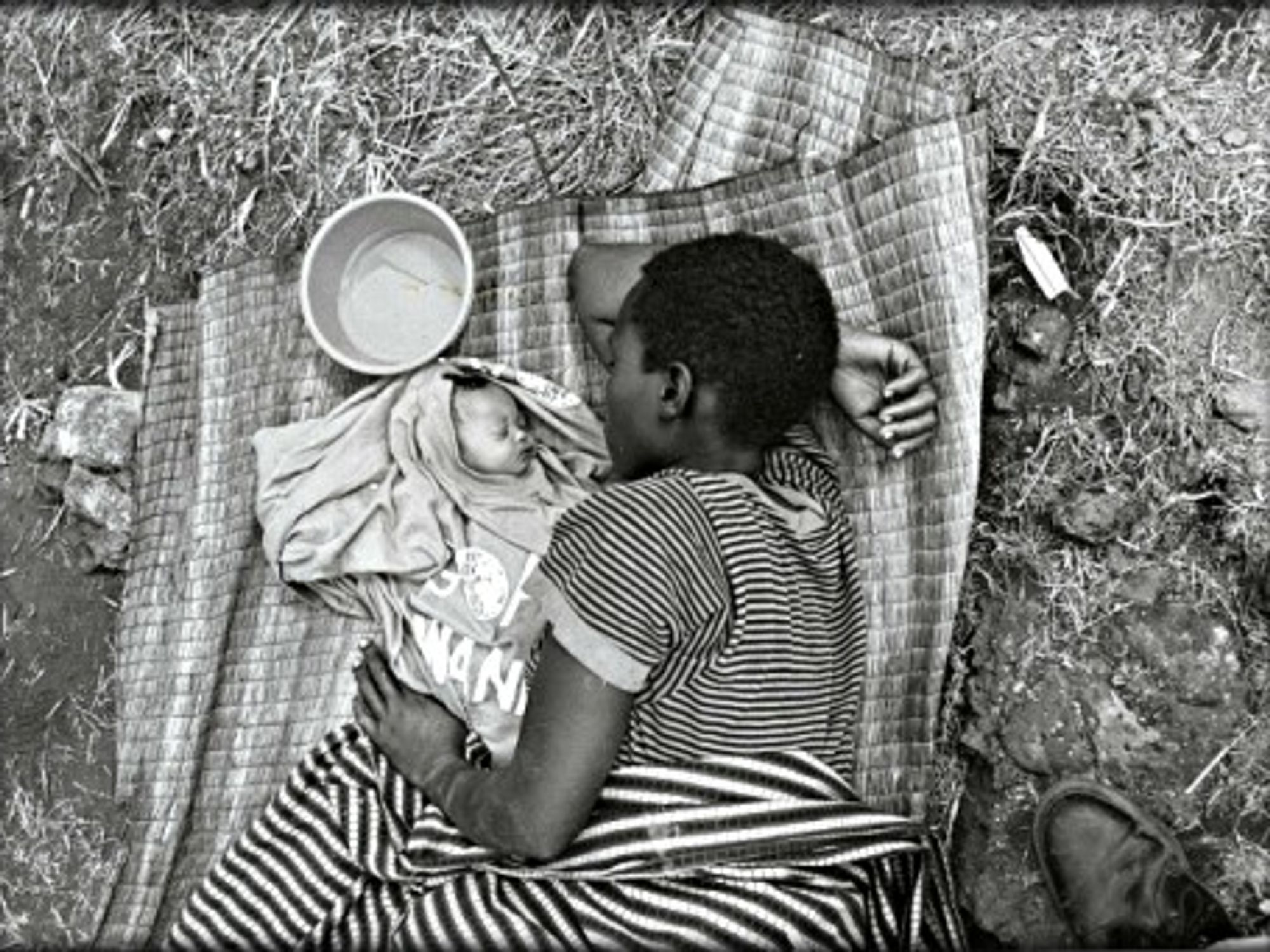 Rwandan mother and baby sleeping in a refugee camp