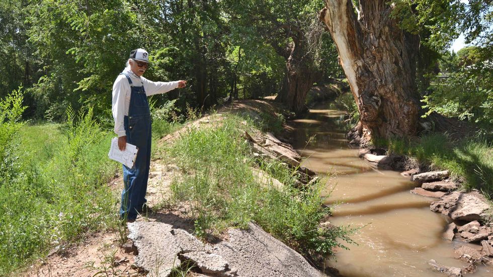 Santiago Maestas, president of the South Valley Regional Association of Acequias, stands next to the Pajarito acequia in Albuquerque, New Mexico.