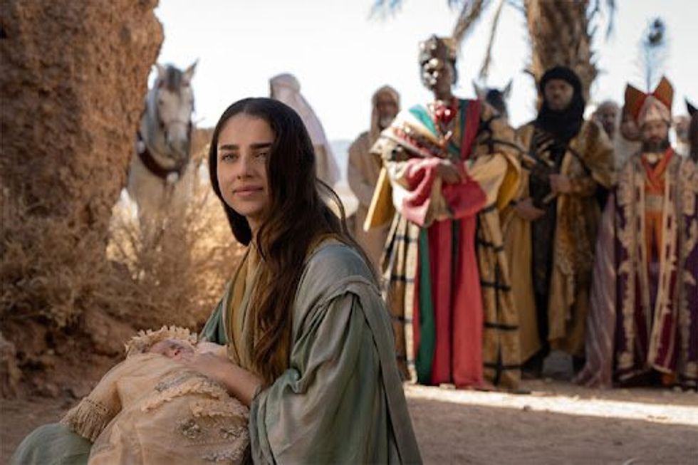 Scene from a movie depicting Mary, the mother of Jesus, tenderly holding the infant in her arms,