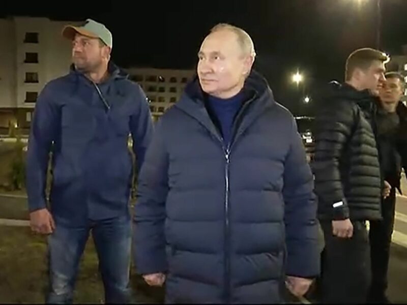 screen grab of Putin in a dark down jacket