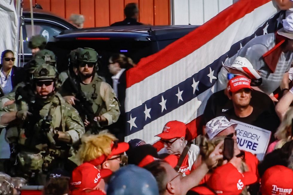 Screenshot of a video showing security forces alongside panicked participants in Trump's rally in Butler, immediately after an assassination attempt on the former U.S. president