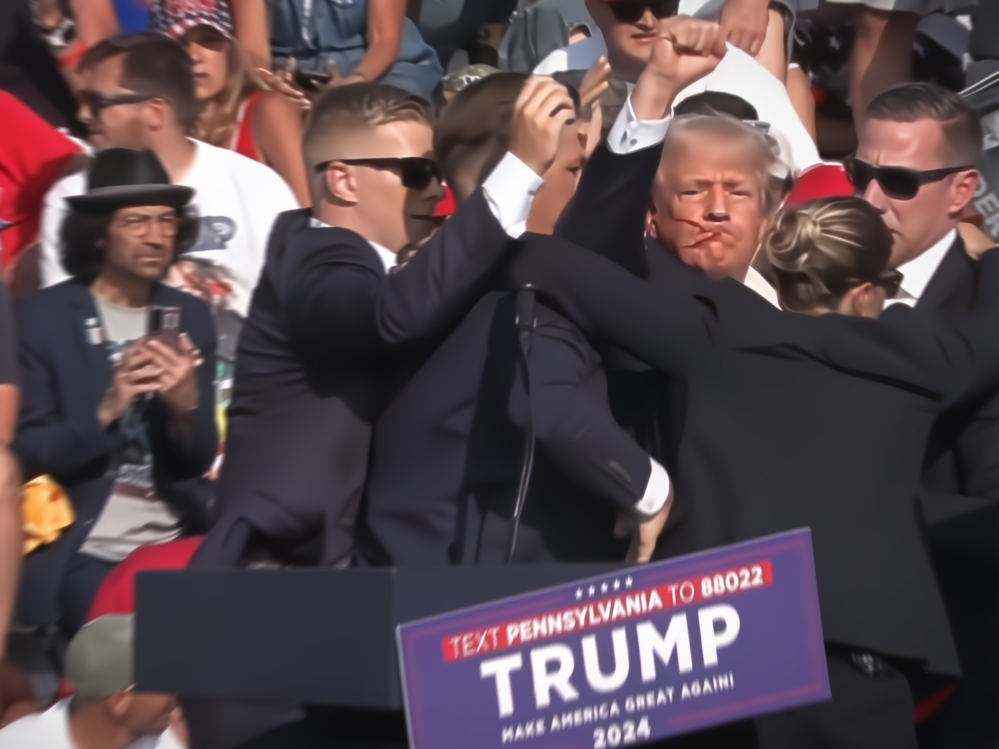 Screenshot of a video that captured the assassination on Donald Trump, showing the former U.S. president with a bloodied face and defiantly raising his fist