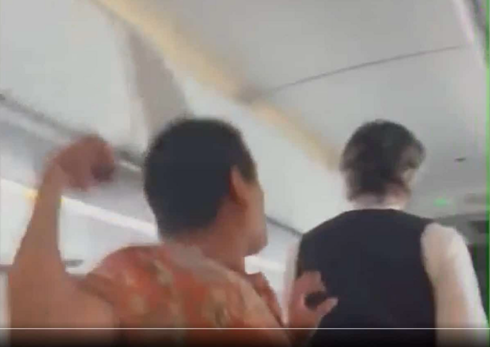 Screenshot of cellphone footage of a passenger punching a flight attendant on a flight from Mexico to California in September 2022